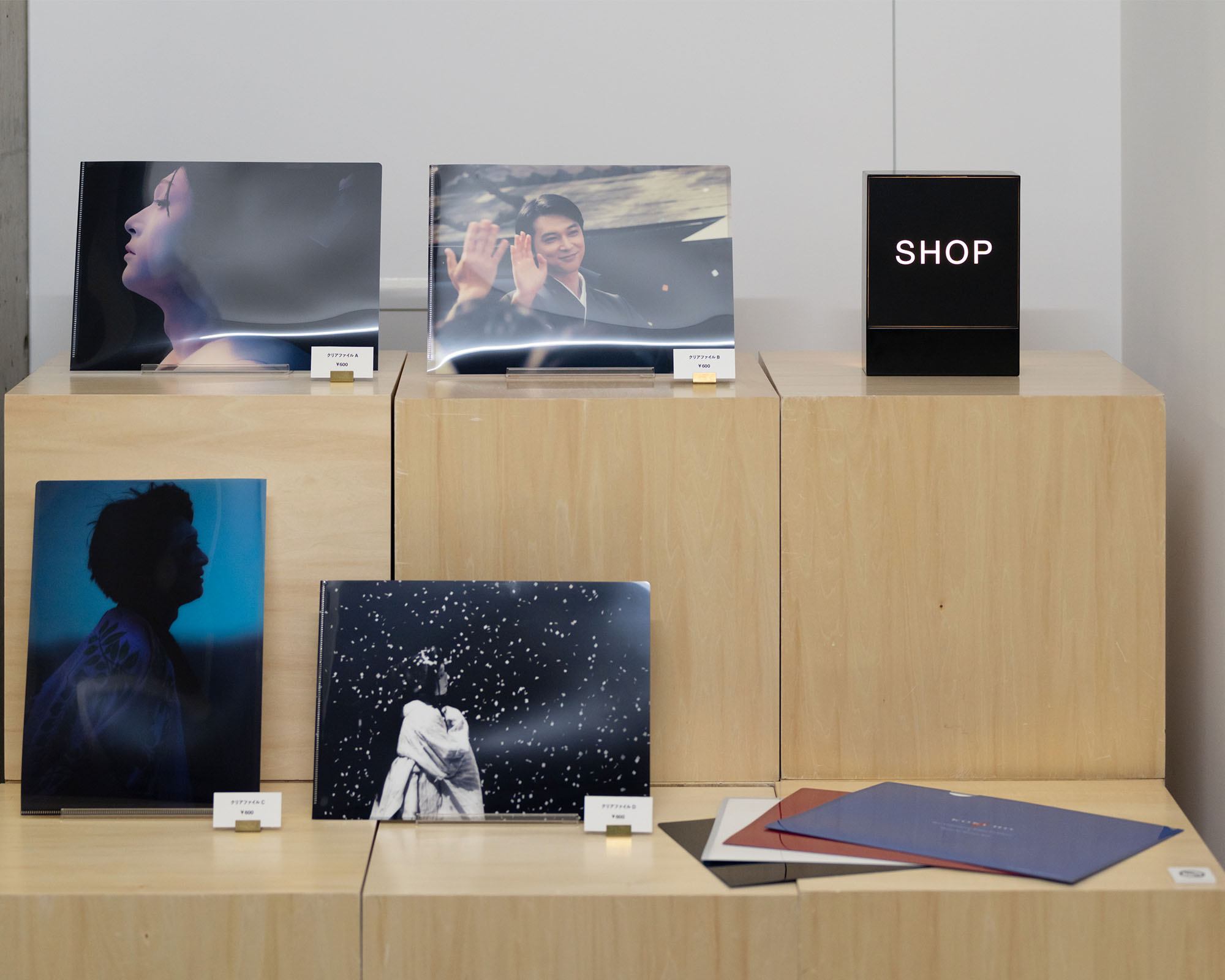 4Fショップに並ぶ展示関連グッズ。アイテムが木製の台に整然と配置され、購入できるようになっている。